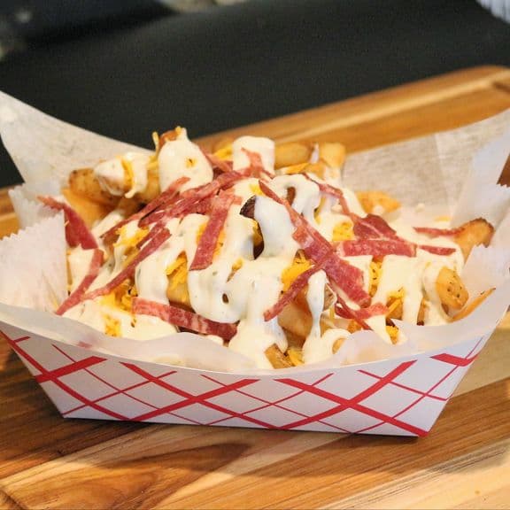 Loaded Fries - Crispy french fries topped with ranch dressing, turkey bacon, and melted cheddar cheese. The ultimate loaded fry experience.
