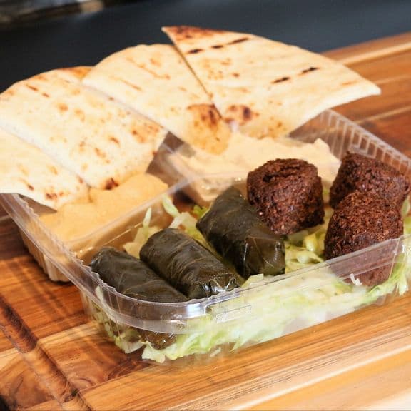 Mediterranean Mix - An authentic Mediterranean platter with 3 hand-rolled grape leaves stuffed with seasoned rice, 3 freshly made falafel, creamy house-made hummus, traditional tzatziki sauce, and warm pita bread.